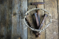 Crown of Thorns and Three Nails With Hammer on Wooden background